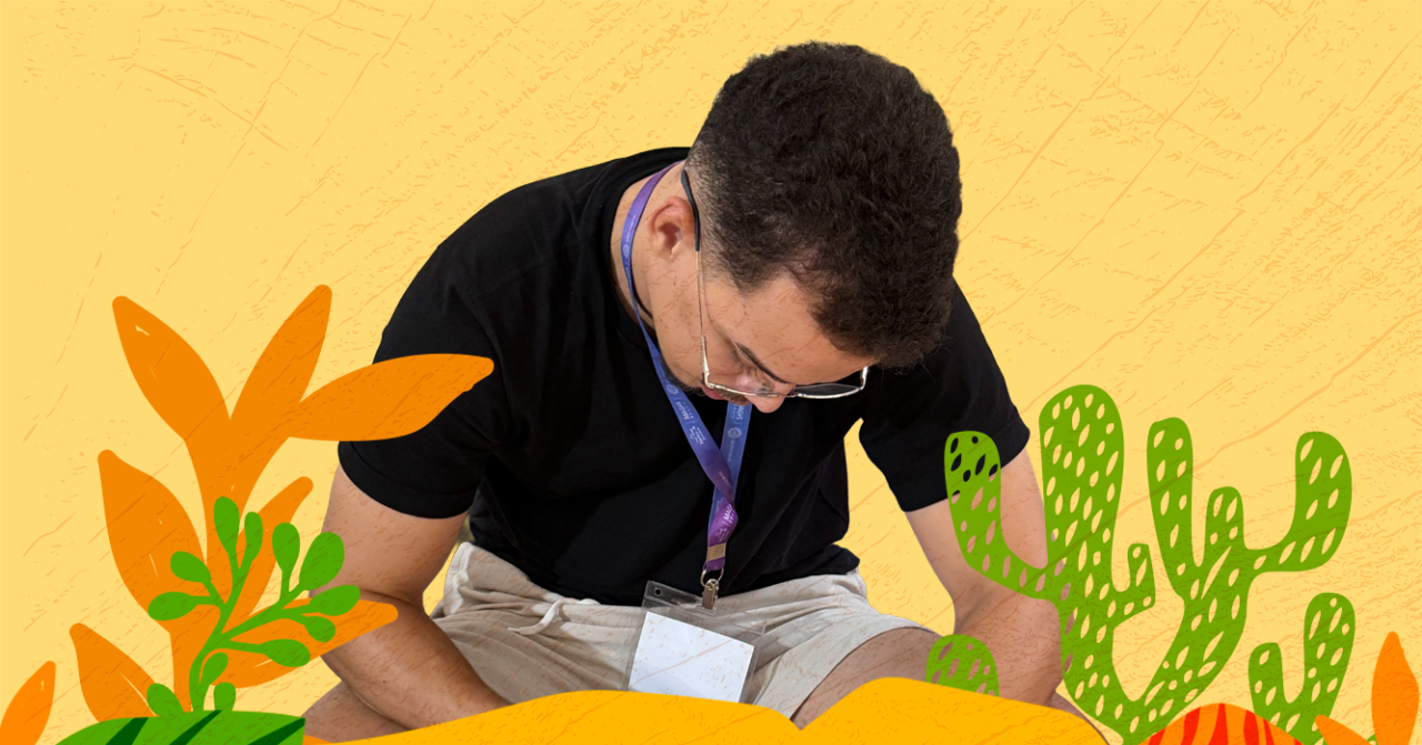 Homem sentado e inclinado para frente, em atividade de escrita ou reflexão, sobre fundo amarelo com ilustrações em tons de laranja e verde que remetem à natureza e à vegetação.