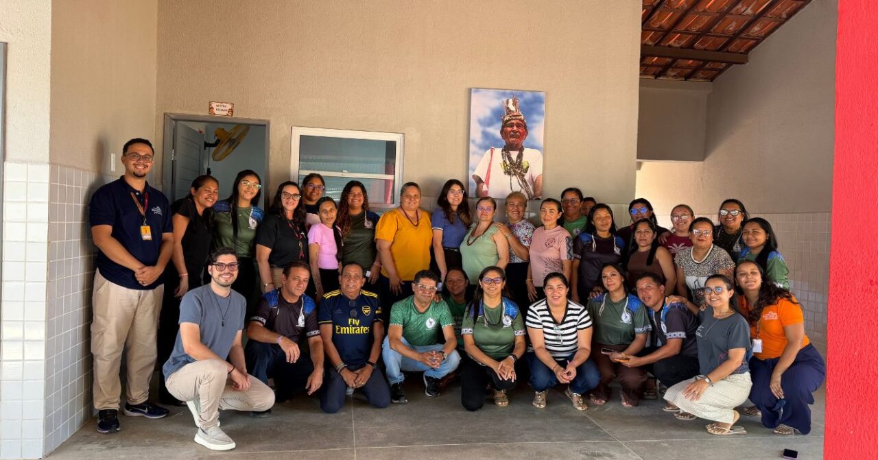 Grupo de participantes do Projeto Farol reunido na Escola Cacique Antônio Ferreira da Silva, em Caucaia (CE), durante atividade de reflexão com estudantes, professores e funcionários da comunidade indígena Anacé.